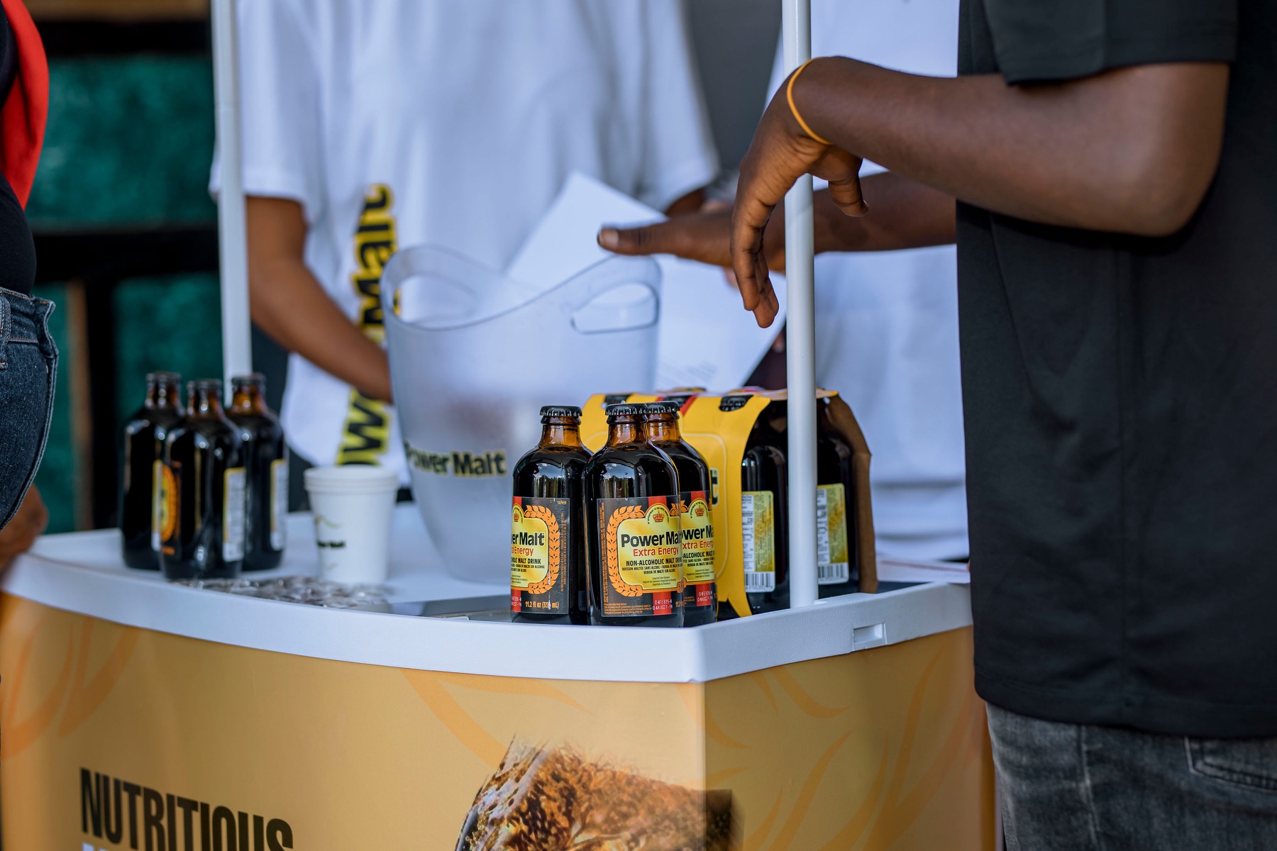 Power Malt bottles displayed at an activation stand